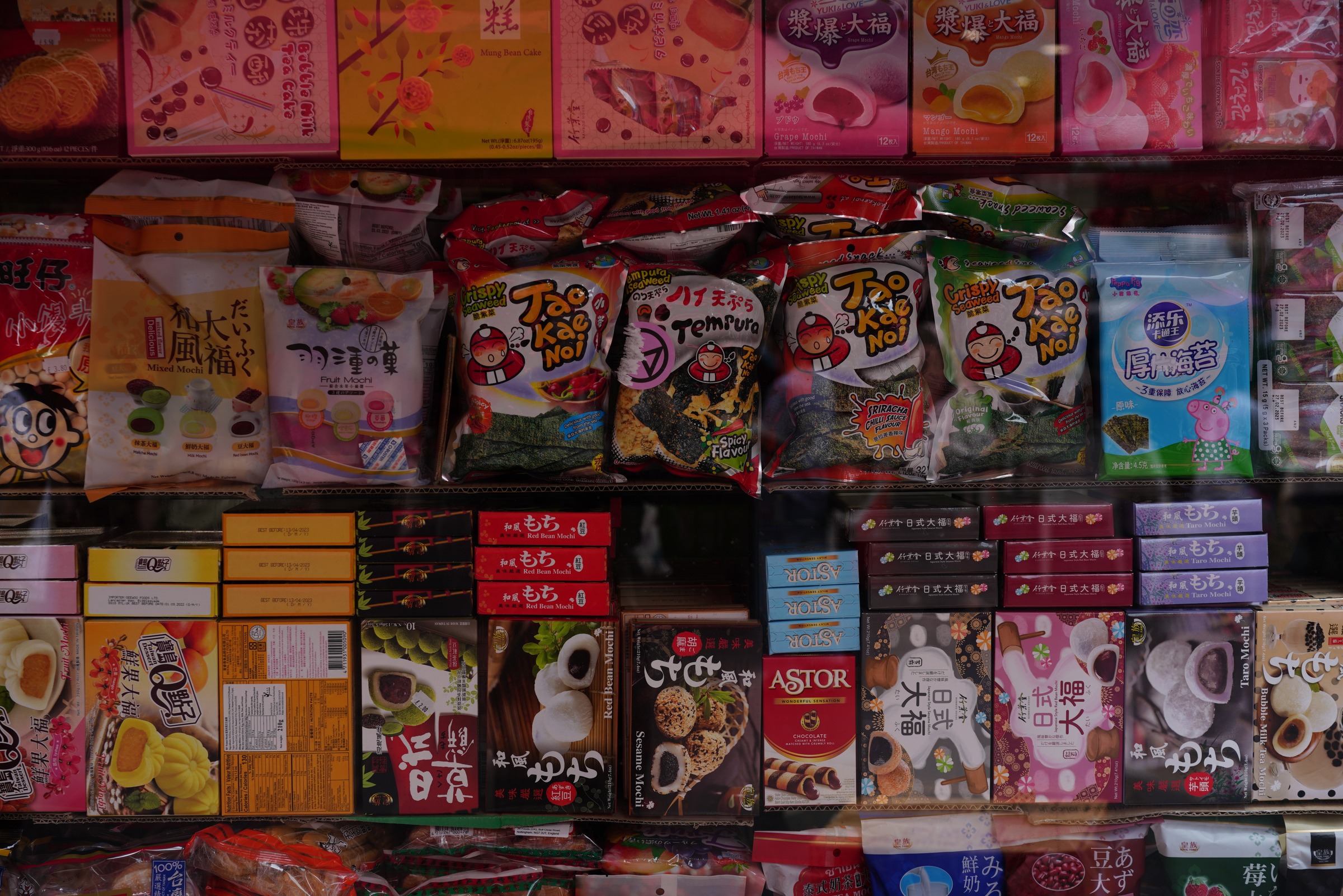 Colourful packaged snacks form a dense grid behind glass.