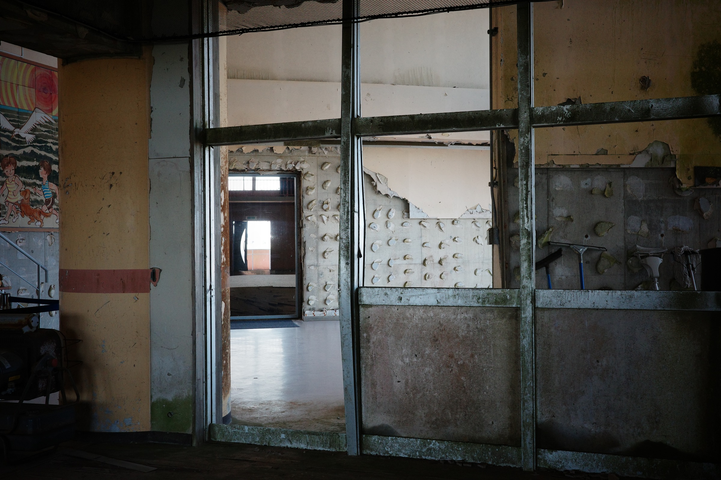 Layered doorframes open onto an empty corridor and a patch of light.